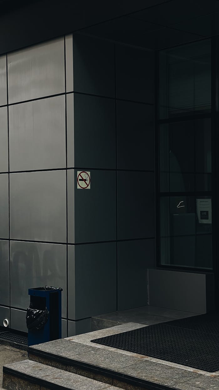 Contemporary building facade featuring a no smoking sign and trash can outside in Vladivostok, Russia.